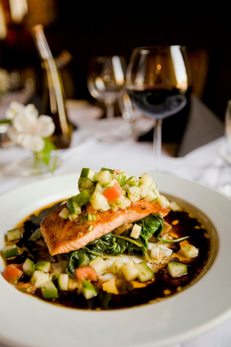 Lomo de pescado a la brasa sobre su jugo, emplatado para el menú Norte. Imagen de muestra.