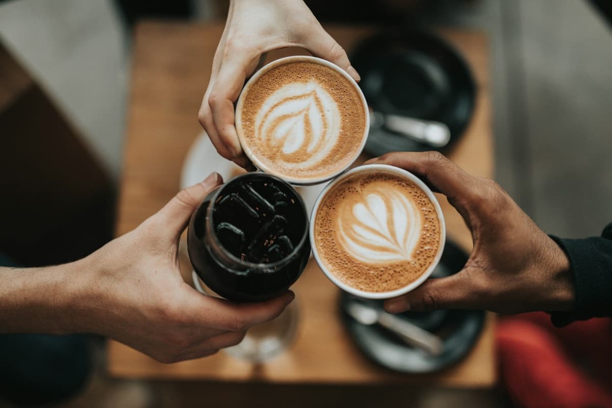 Tres cafés durante la sobremesa sobre una mesa de madera. Imagen de muestra.