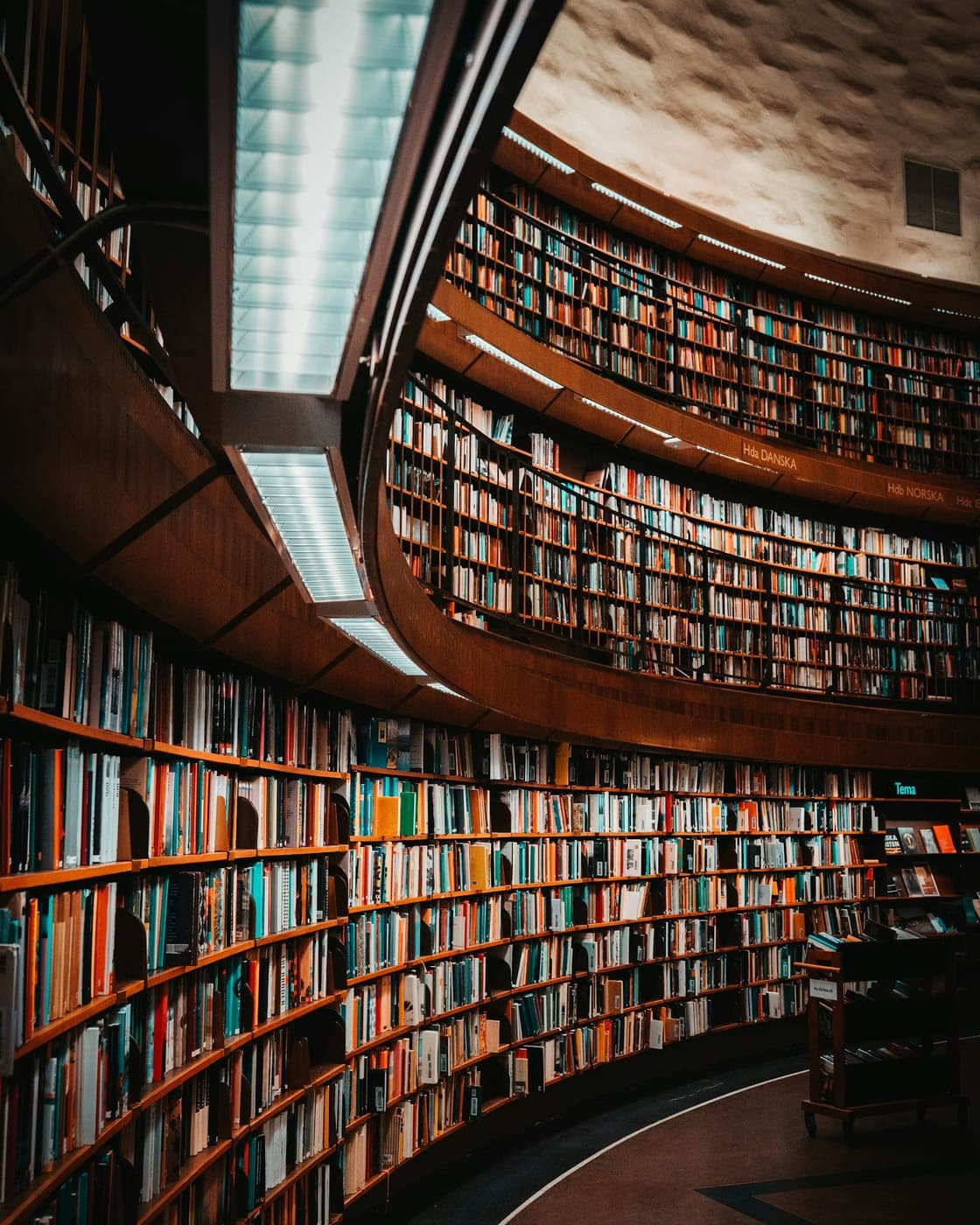Biblioteca de volumenes juridicos encuadernados en una sala curva con luz natural. Imagen de muestra de Varela Legal.