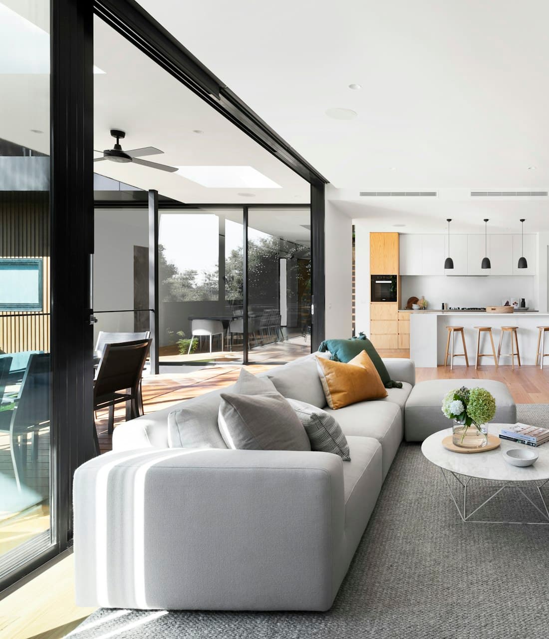Salón luminoso con grandes ventanales y salida al jardín, vivienda de muestra preparada para la visita